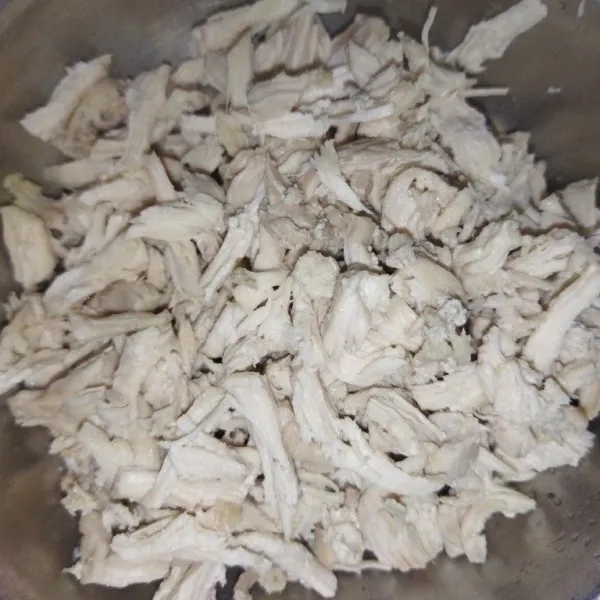Rebus daging ayam dengan 600 ml air hingga matang, angkat lalu suwir-suwir.