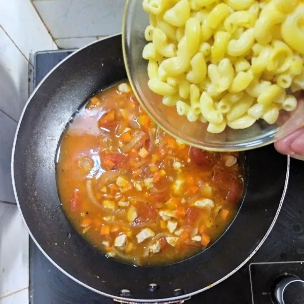 Tambahkan wortel dan masak hingga layu, lalu tambahkan saus bolognese, makaroni dan air kaldu. Rebus hingga makaroni al dente.