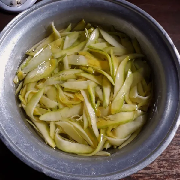 Rendam mangga dengan air dan kapur sirih, diamkan 1 jam. Cuci bersih dan peras mangga agar airnya berkurang.