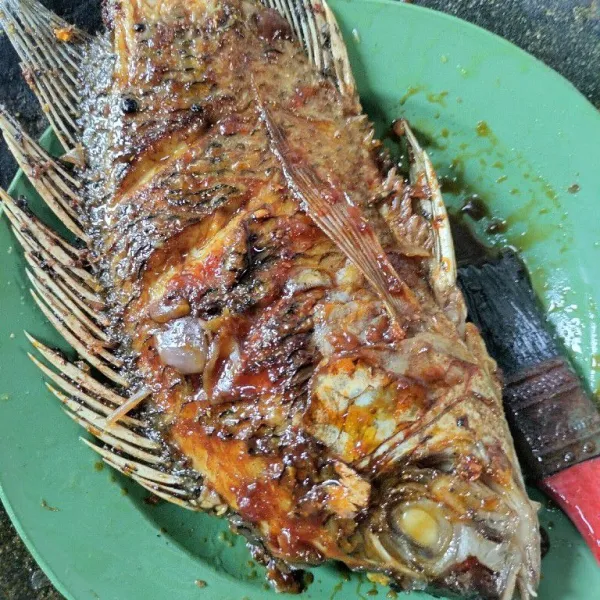 Oles ikan yang akan dibakar dengan bumbu sampai rata.