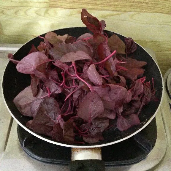 Masukkan daun bayam lalu aduk hingga setangah layu.