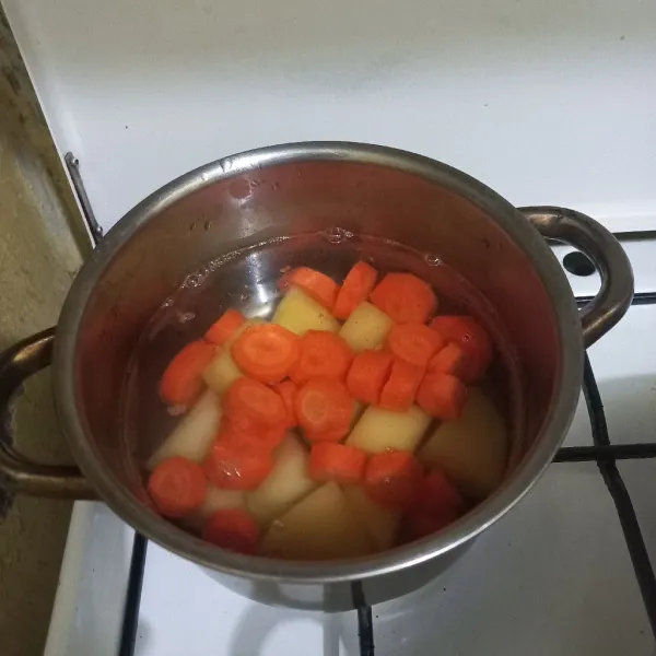 Rebus irisan kentang dan wortel hingga setengah matang.
