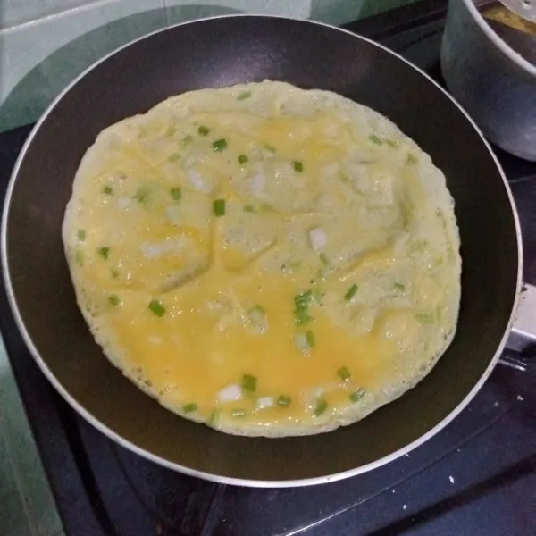 Goreng telur dadar di teflon.