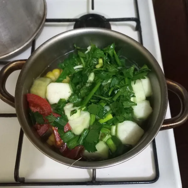 Tambahkan irisan bawang daun, seledri dan tomat masak hingga matang.