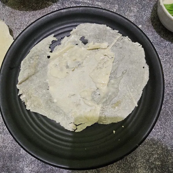 Tata 2 lembar kulit lumpia, oles larutan terigu di sambungan kulit lumpia.