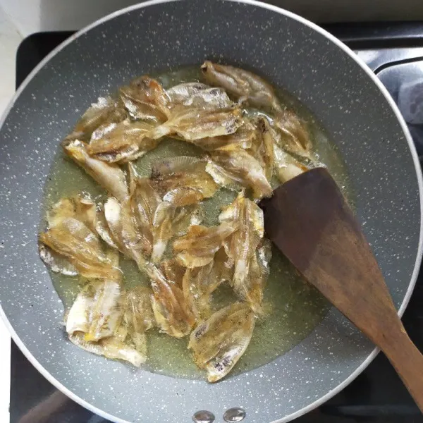Panaskan minyak, kemudian goreng ikan asin kaca hingga matang dan kering lalu angkat.