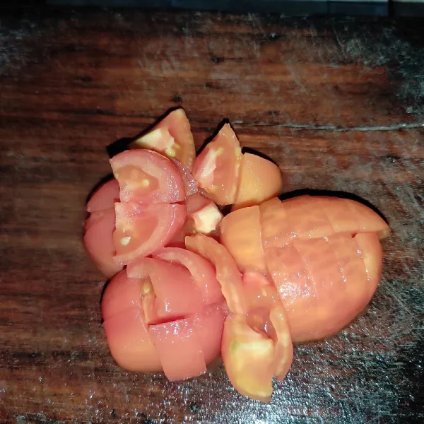 Kupas kulit ari tomat yang tadi sudah di rebus lalu potong-potong.