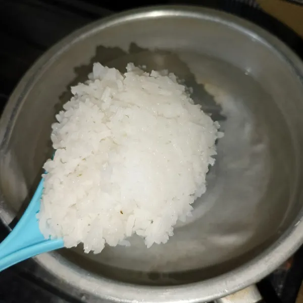 Rebus air dan nasi di panci.