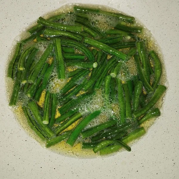 Goreng kacang panjang hingga layu.