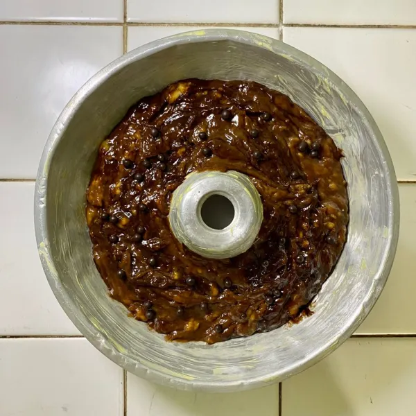 Siapkan loyang, lalu olesi dengan margarin. Tuangkan adonan, lalu beri topping chocolate chips.