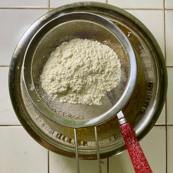 Tambahkan tepung terigu, ayak lalu aduk rata.