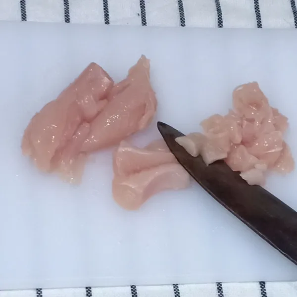Cincang kasar setengah bagian daging ayam beserta kulitnya.