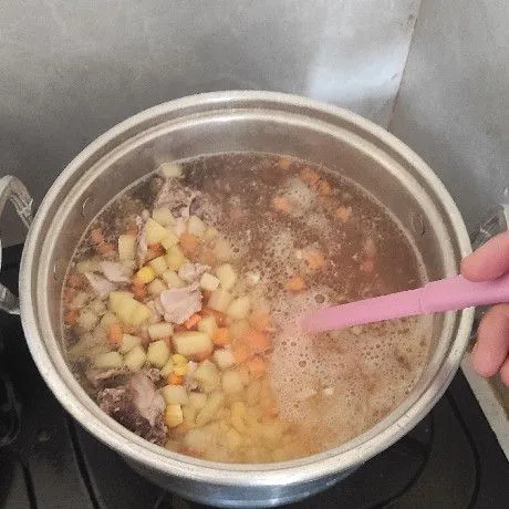 Air sudah mendidih masukan tumisan ayam, kentang, wortel dan jagung masak sampai sayur setengah matang.