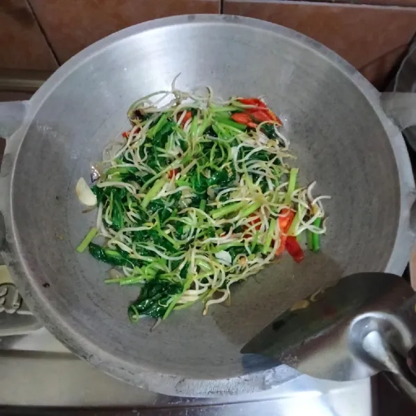 Masak hingga bayam layu, lalu tes rasa kemudian matikan api.