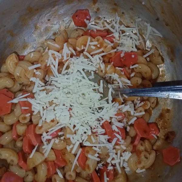 Campur macaroni dengan saus bolognese, keju parut, oregano, dan parsley, aduk rata