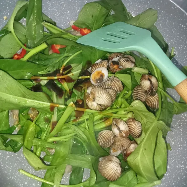 Masukkan kangkung, kerang, gula, saus tiram dan kaldu jamur, aduk rata.