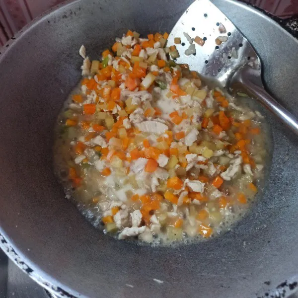 Setelah bumbu matang, tambahkan air secukupnya, kemudian masukkan wortel, kentang, dan ayam cincang. Bumbui dengan garam, gula, lada bubuk, dan kaldu bubuk. Aduk rata dan masak hingga empuk dan matang.