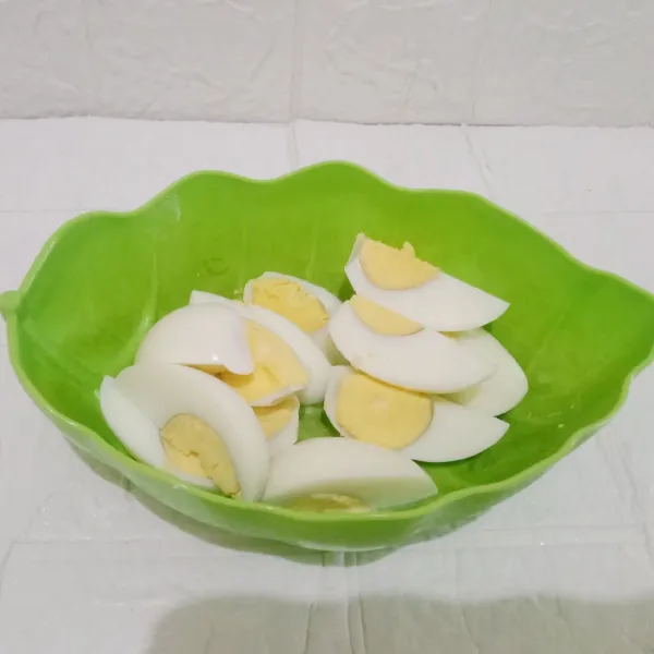 Siapkan telur yang sudah direbus kemudian potong menjadi empat bagian.