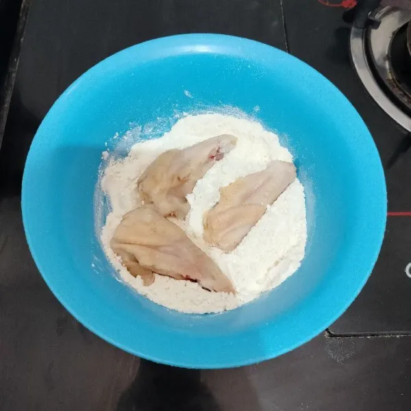 Kemudian gulingkan ayam ke dalam tepung terigu yang sudah di beri sedikit garam. Lumuri hingga rata.