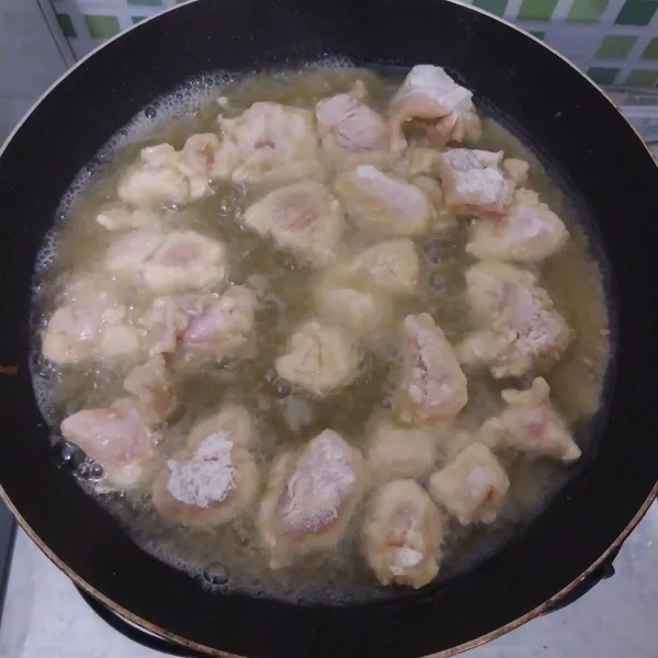 Goreng ayam di minyak panas dengan api sedang.