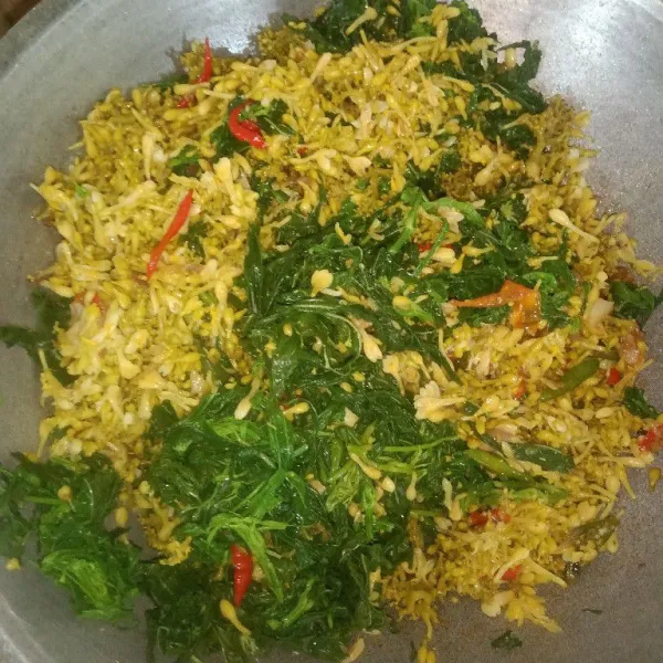 Masukkan bunga pepaya dan daun ubi, aduk rata dan tambahkan garam, gula dan penyedap.