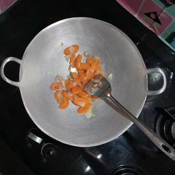 Panaskan secukup nya minyak, kemudian tumis kedua bawang hingga harum, masukan wortel, beri air sedikit lalu tumis sebentar hingga wortel agak layu.