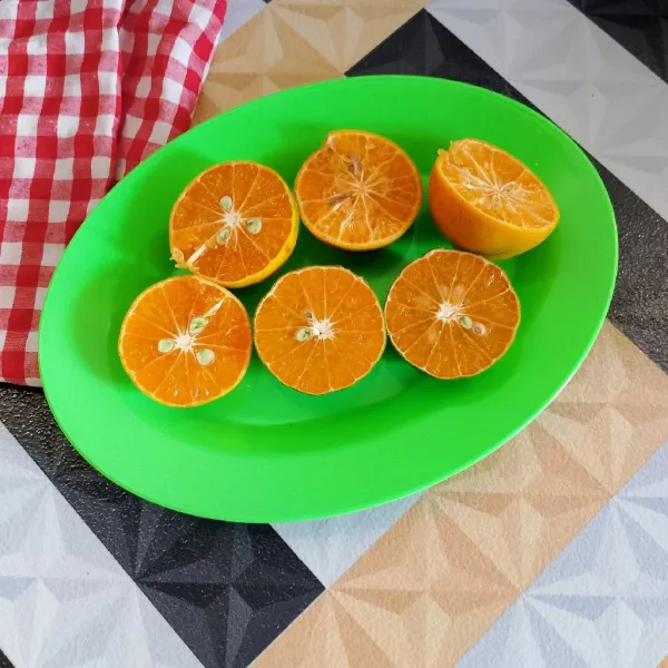 Potong jeruk manis jadi dua bagian.