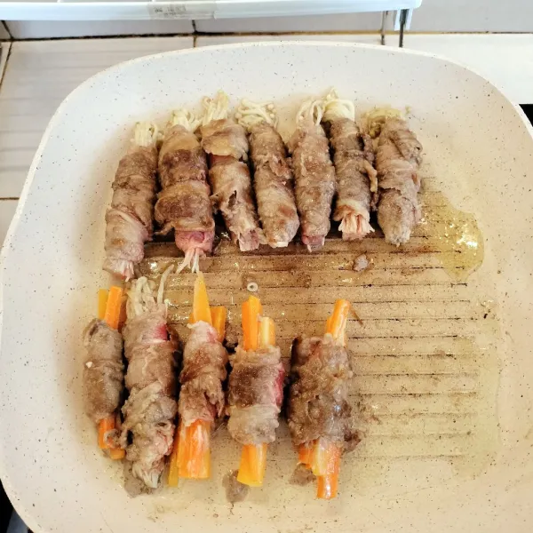 Panaskan sedikit minyak, panggang terlebih dahulu Beef Roll hingga setengah matang.