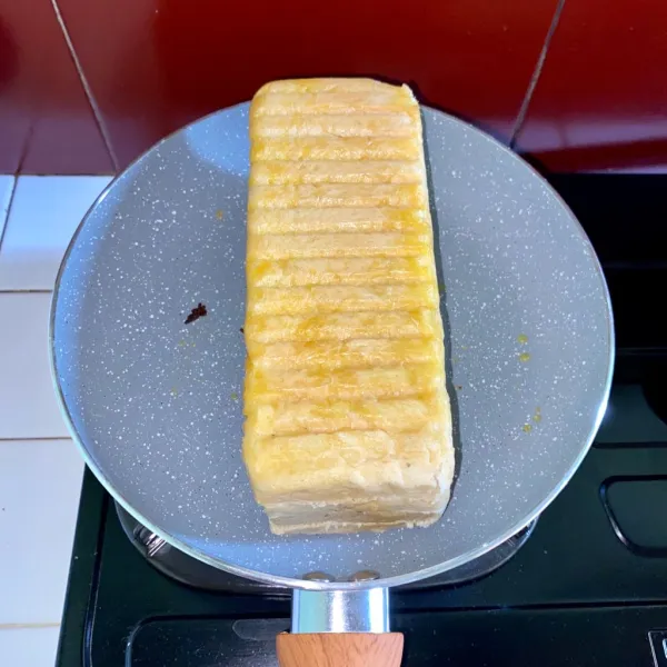 Panggang roti diatas teflon yang telah diolesi margarin, lalu balik kesisi lainnya.