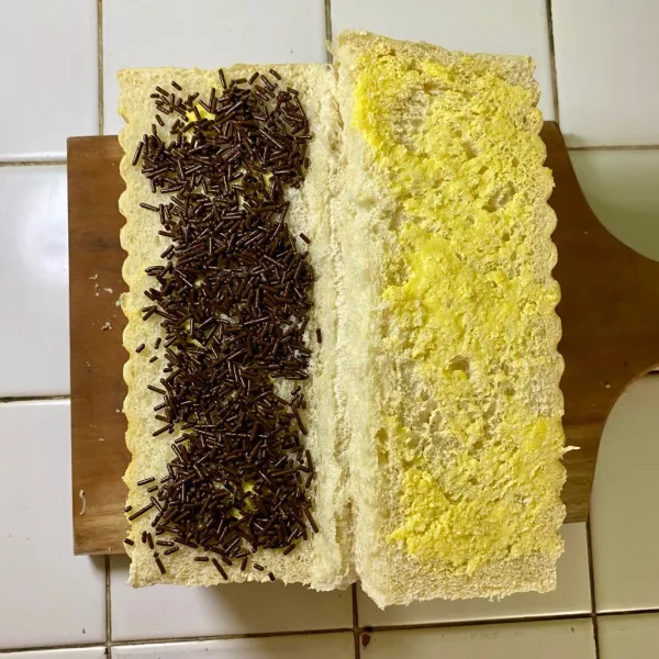 Olesi setiap bagian roti dengan margarin, lalu beri isian messes coklat, saus coklat dan keju parut.
