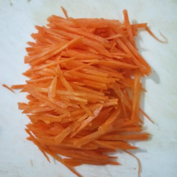Potong memanjang wortel tipis-tipis.