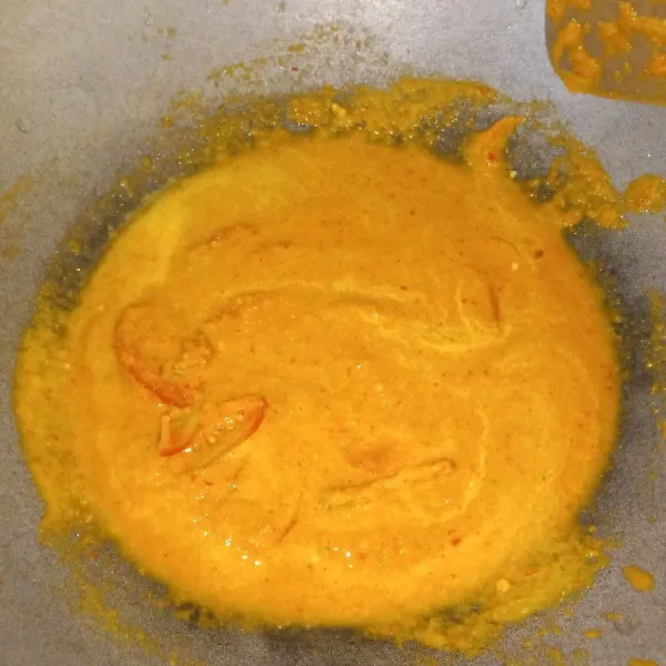 Haluskan bawang merah, bawang putih, cabe merah, cabe rawit, kunyit, jahe, kemiri dan ketumbar, tambahkan tomat, dan aduk rata.