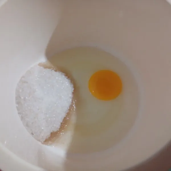 Campur gula dan telur, kocok hingga gula larut.