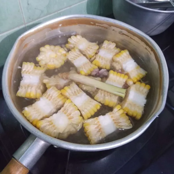 Masukkan jagung, bawang merah, lengkuas, kunci, dan serai.