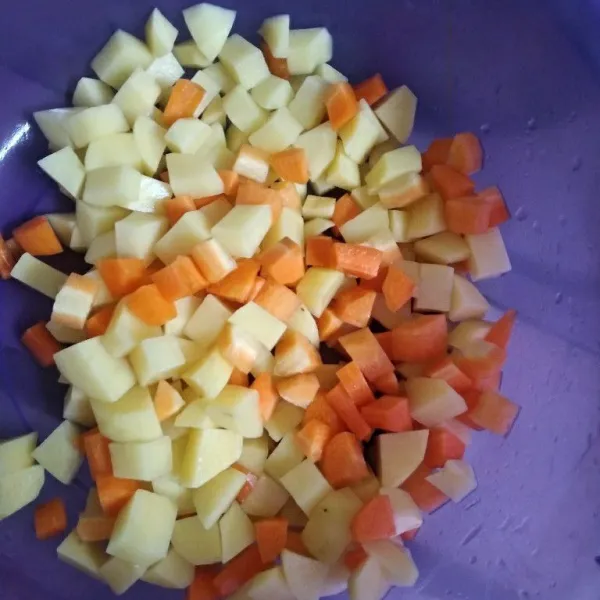 Potong dadu kentang dan wortel.