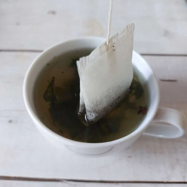 Tambahkan teh celup, biarkan sebentar sampai teh menjadi pekat.