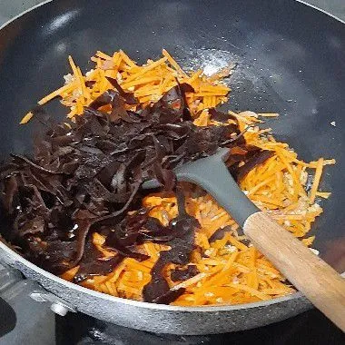 Kemudian masukkan wortel dan jamur kuping, aduk rata dan masak hingga layu