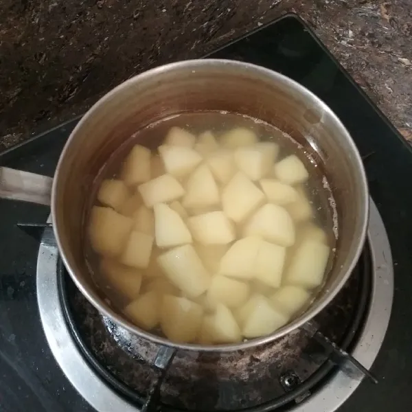 Kupas kentang, cuci bersih, potong dadu, masukkan ke dalam air mendidih, dan rebus hingga matang.
