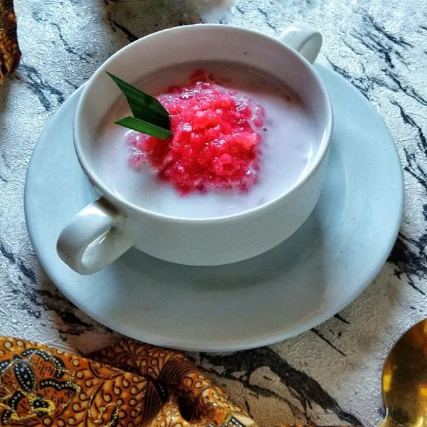 Sajikan bubur mutiara dalam mangkuk lalu siram dengan santan kental.