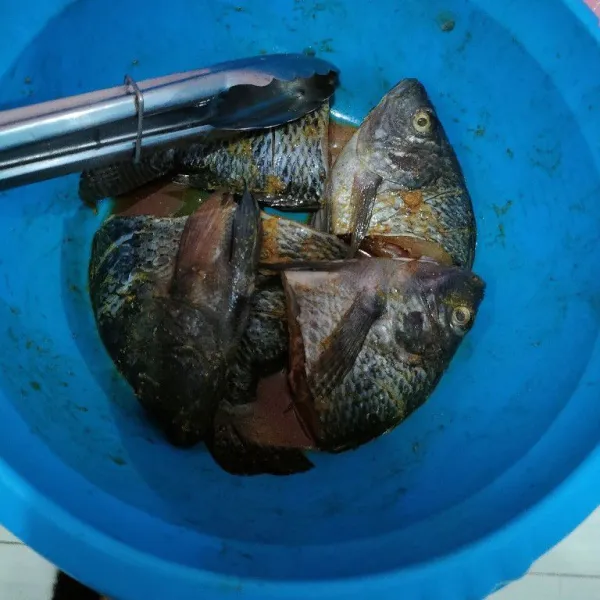 Bersihkan ikan, kemudian baluri bumbu instan ikan goreng, aduk merata.