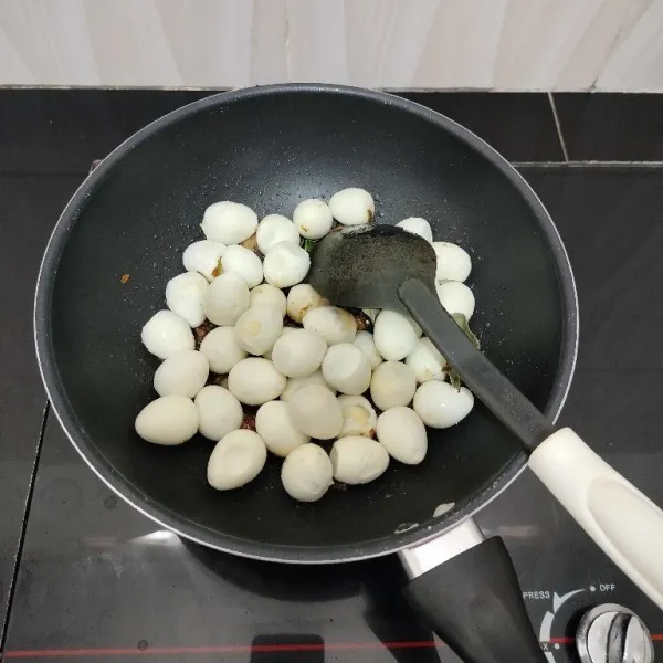 Masukkan telur puyuh. Aduk rata bersama bumbu.