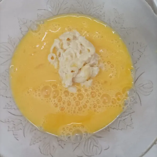 Potong-potong persegi Mac n cheese, celupkan dalam kocokan telur.
