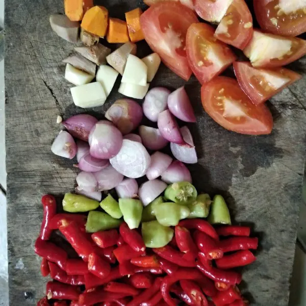 Potong-potong bawang merah, bawang putih, cabe, jahe, kunyit, dan tomat.