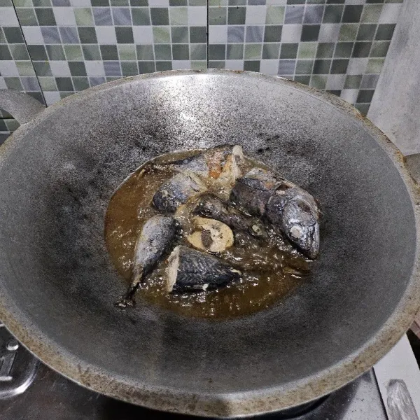 Goreng ikan tongkol dalam minyak panas dengan api sedang.