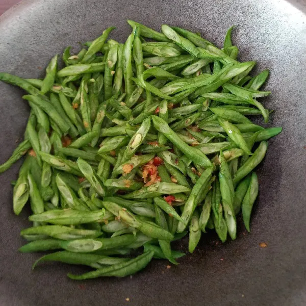 Masukkan kacang, tambahkan sedikit saja air. Tutup dan masak sampai setengah matang.