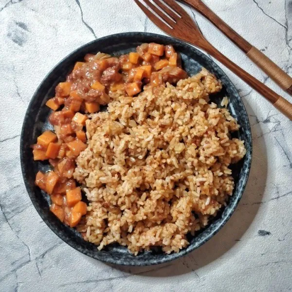 Tata nasi di piring saji, siram tumisan kornet wortek di sisinya, siap disajikan.