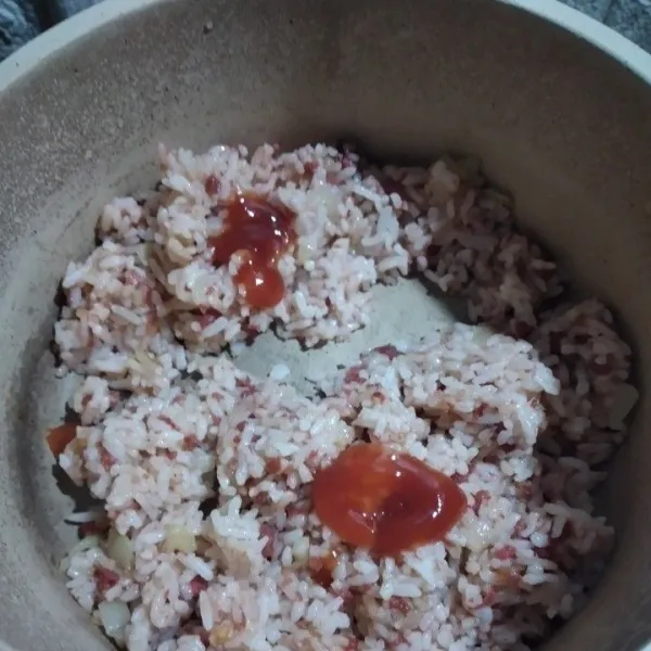 Tambahkan saos sambal dan saos tomat, kaldu bubuk, aduk semua bahan lalu besarkan api kompor, masak hingga nasi tercampur merata ddngan semua bahan, sisihkan.