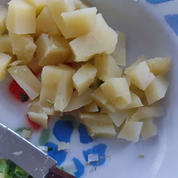 Rebus kentang hingga matang, lalu kupas dan potong