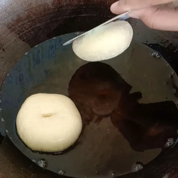 Tahap akhir, panas kan minyak dengan api kecil cenderung sedang . Goreng donat dengan teknik terbalik seperti di foto ya. Setelah donat masuk kedalam penggorengan ambil sumpit lalu balik si donat tadi, ini supaya permukaan donatnya mulus dan tidak bergelembung. Goreng sampai donat kuning keemasan, lalu balik lagi pakai sumpit. Jangan dibolak balik agar tidak menyerap minyak, tunggu sampai kekuningan lalu angkat dan sajikan dengan taburan gula halus atau glaze .