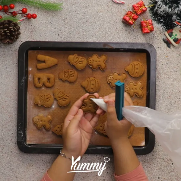 Hias menggunakan icing sugar, dan gingerbread cookies siap untuk disajikan.